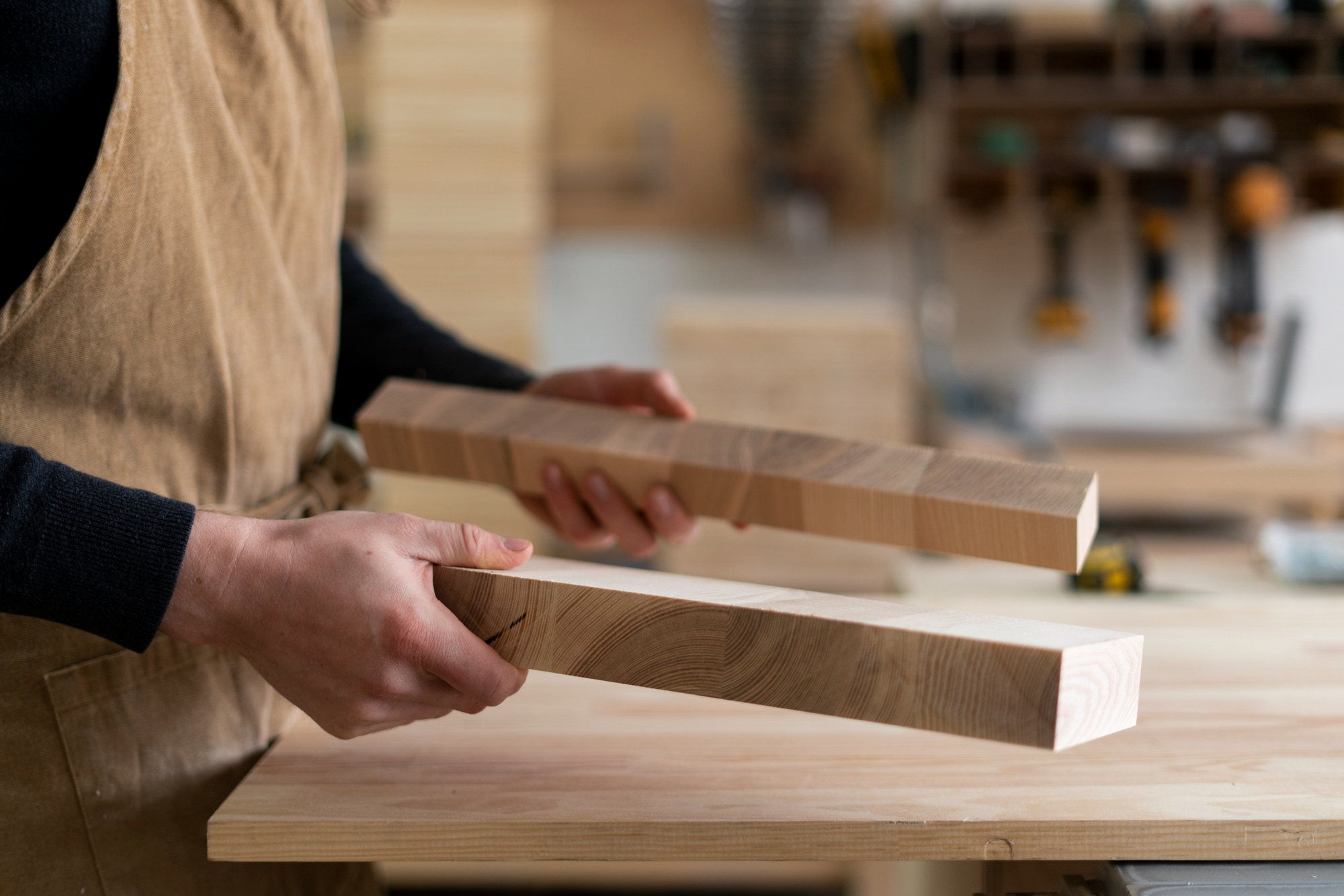 Worker holding finished wood boards in a workshop